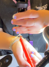 Load image into Gallery viewer, Client welding her own permanent jewelry bracelet with the help of the mew PJ wand
